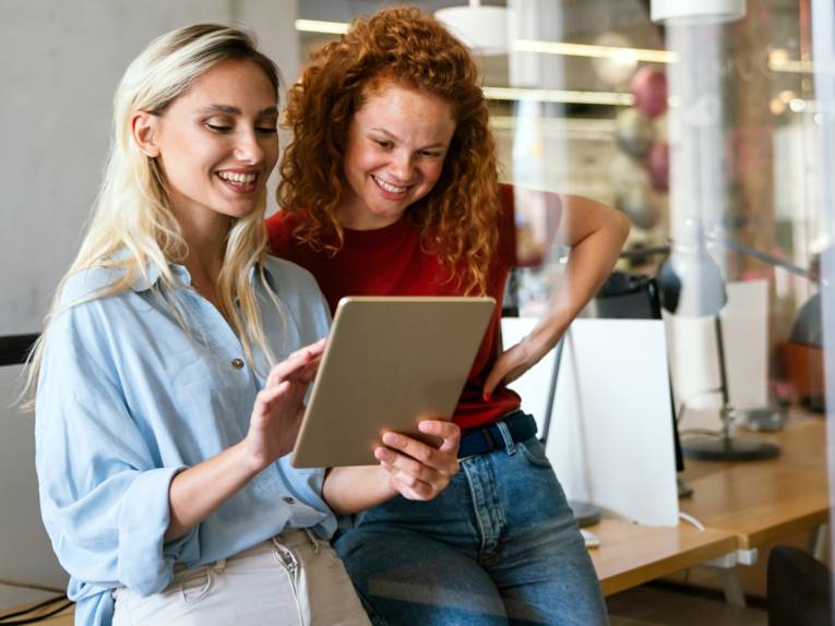 Zwei junge Frauen schauen gemeinsam auf ein Tablet